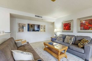 A living room with a sofa, a coffee table, and a lamp. There are framed pictures on the wall. - Renaissance Tower 317 (Myrtle Beach)