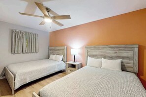 A hotel room with two beds, a ceiling fan, a nightstand, and a lamp. - Tilghman Beach and Golf 6003 (North Myrtle Beach)