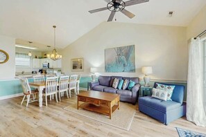 A living room with a dining table, chairs, a sofa, a coffee table, and a ceiling fan. - Wild Iris Unit 303 Condo (Myrtle Beach)