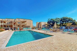 A swimming pool with lounge chairs and a building with balconies. - Ocean Bridge 2-C5 Sunrise Shore (Myrtle Beach)