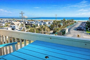 A view of a beachside RV park with multiple RVs parked along the road, a clear blue sky, and the ocean in the background. - Ocean Bridge 2-C5 Sunrise Shore (Myrtle Beach)