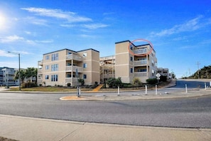 A multi-story residential building with balconies, a roundabout, and a clear sky. - Ocean Bridge 2-C5 Sunrise Shore (Myrtle Beach)