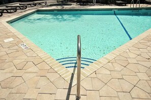 A swimming pool with a metal ladder and tiled deck. - Ocean Creek Unit G-8 (Myrtle Beach)