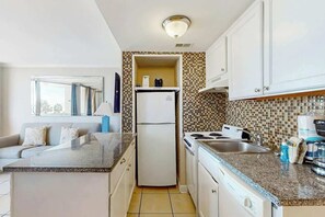 Eine kleine Küche mit Kühlschrank, Herd und Spüle.
