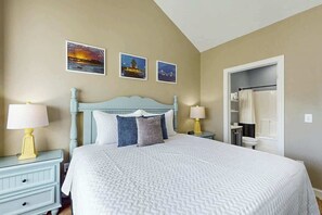 A hotel room with a bed, nightstands, a wardrobe, and a bathroom visible through an open door. - Myrtlewood Golf & Beach Retreat (Myrtle Beach)