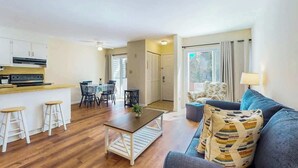 A modern living space with a kitchen, dining area, and a seating area with a sofa and chairs. - Brandywine South Unit 4G (Myrtle Beach)