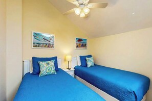 A room with two beds, a ceiling fan, and two wall-mounted pictures. - Brandywine South Unit 4G (Myrtle Beach)