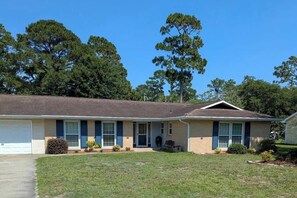 A single-story house with a front porch, a garage, and a well-maintained lawn. - Beach House Hideaway (North Myrtle Beach)