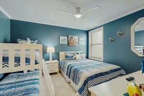 A bedroom with a bed, bedside tables, a desk, and a ceiling fan. - Surfmaster by the Sea 208 (Murrells Inlet)