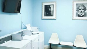 Une pièce équipée d’un lave-linge, d’un bureau avec un ordinateur et de deux chaises.