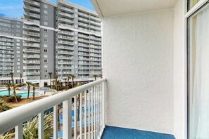 A balcony with a view of a hotel building and a swimming pool. - Sea Watch Unit 303 Condo (Myrtle Beach)