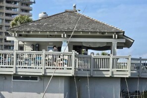 Ein Gebäude direkt am Strand mit Balkon, überdachtem Bereich und Blick aufs Meer.