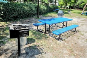 A picnic table with benches in a park setting. - Ocean Creek Lodge IV - 2287 (Myrtle Beach)