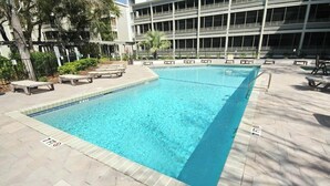 A swimming pool with lounge chairs and a building in the background. - Ocean Creek Lodge IV - 2287 (Myrtle Beach)