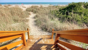 A wooden pathway leading to beachside seating with a view of the ocean. - Windy Hill Dunes 204 (North Myrtle Beach)