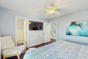 A bedroom with a bed, a ceiling fan, and a painting on the wall. - Livin' the Dream at 26th Ave N (North Myrtle Beach)