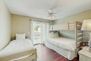 A bedroom with two beds, a ceiling fan, and a window with curtains. - Livin' the Dream at 26th Ave N (North Myrtle Beach)