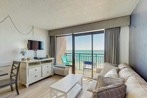 A hotel room with a balcony, a flat-screen TV, a desk, and a sofa. - Sandcastle South 615 (Myrtle Beach)