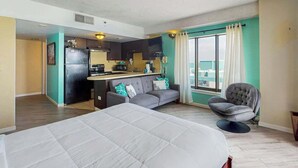 Une chambre d’hôtel avec un lit, un canapé, un coin repas et une vue sur la ville.