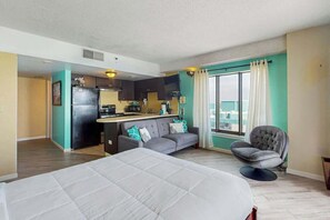 A hotel room with a bed, a sofa, a dining area, and a view of the city. - Palace Resort Unit 1604 (Myrtle Beach)