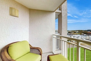Ein Balkon mit Korbstühlen und Blick auf eine Marina.