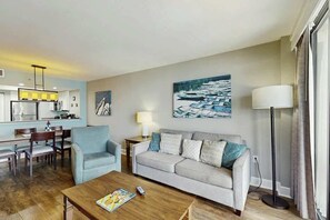 Ein Wohnzimmer mit einer Couch, einem Couchtisch und einem Gemälde von Booten an der Wand.