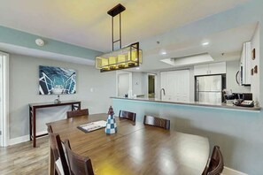 Eine moderne Küche mit weißen Schränken, einem eingebauten Ofen und einem Edelstahlkühlschrank.