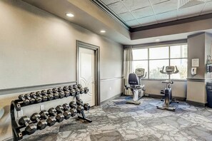 Ein Fitnessraum mit Hanteln, einem Ergometer und einem Laufband.