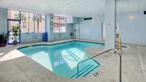 Ein Hallenbad mit freiem Blick nach draußen, einer Rettungswache und einem Schild, das das Tauchen untersagt.