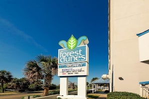 A sign for 'Forest Dunes' with a 'VACANCY' notice, indicating available 1-3BR condos/suites, a bar & grill, and a smoke-free environment.
