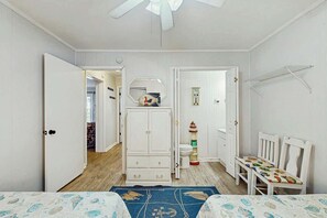 A room with a bed, a wardrobe, a small table with chairs, and a ceiling fan. - Ocean Boulevard Oasis (North Myrtle Beach)