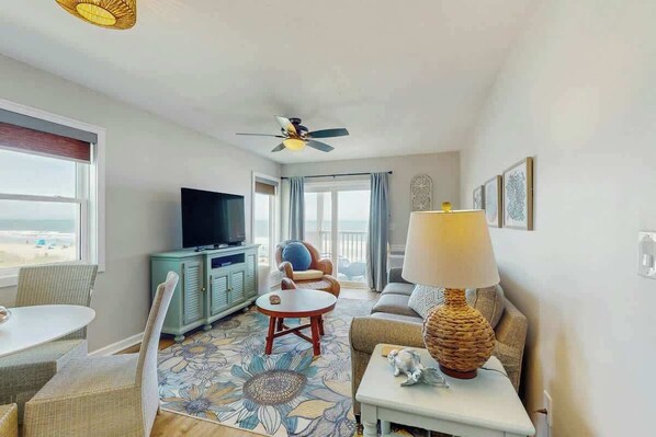 A hotel room with a television, seating area, and a view of the beach. - Ocean Pier 3 Unit - 322 (North Myrtle Beach)