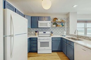 A kitchen with a refrigerator, microwave, stove, and sink. - Ocean Pier 3 Unit - 322 (North Myrtle Beach)