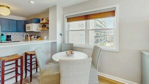 Une cuisine moderne avec un coin repas, une grande fenêtre offrant une belle vue et une table ronde avec des chaises.