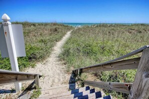 A sandy beach path leading to the ocean with a wooden fence and a white structure on the left. - Ocean Pier 3 Unit - 322 (North Myrtle Beach)