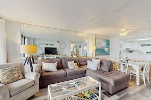 Ein modernes Wohnzimmer mit Sofa, Couchtisch und Essbereich.