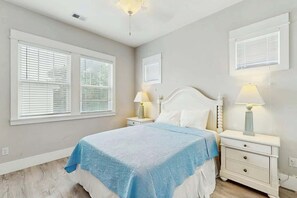 A bedroom with a bed, two bedside tables with lamps, and a window with blinds. - Cloisters on the Ocean 326 (Myrtle Beach)