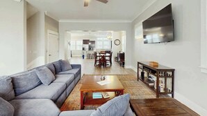 A living room with a sofa, coffee table, and a television mounted on the wall. - Cloisters on the Ocean 326 (Myrtle Beach)