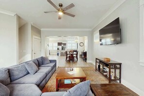 A living room with a sofa, coffee table, and a television mounted on the wall. - Cloisters on the Ocean 326 (Myrtle Beach)