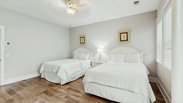 A room with two beds, a ceiling light fixture, and a window with blinds. - Cloisters on the Ocean 326 (Myrtle Beach)