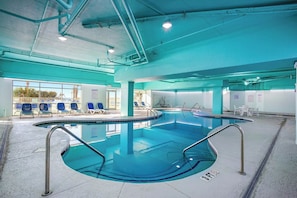 An indoor swimming pool with clear water, surrounded by lounge chairs and a tiled floor. - Bay Watch Resort 0538 (North Myrtle Beach)