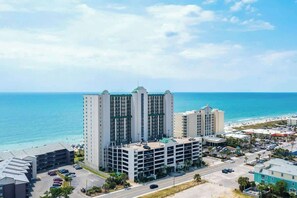 A high-rise hotel with multiple floors, a parking garage, and a view of the ocean. - Ashworth Unit 1305 Condo (North Myrtle Beach)