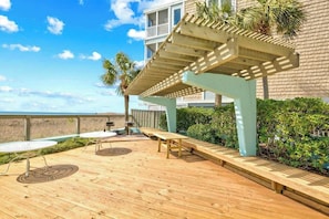 Eine Holzterrasse mit Sitzgelegenheit und einer Pergola.