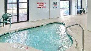 An indoor swimming pool with a no lifeguard on duty sign, a depth marker, and a glass safety warning. - Palms Resort Unit 404 (Myrtle Beach)