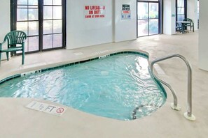 Ein Hallenbad mit Schild, das auf fehlende Badeaufsicht hinweist, einer Tiefenmarkierung und einer Warnung vor Glas.