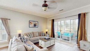 A living room with a sectional sofa, a coffee table, and a ceiling fan. - Wild Iris Unit 101 Condo (Myrtle Beach)