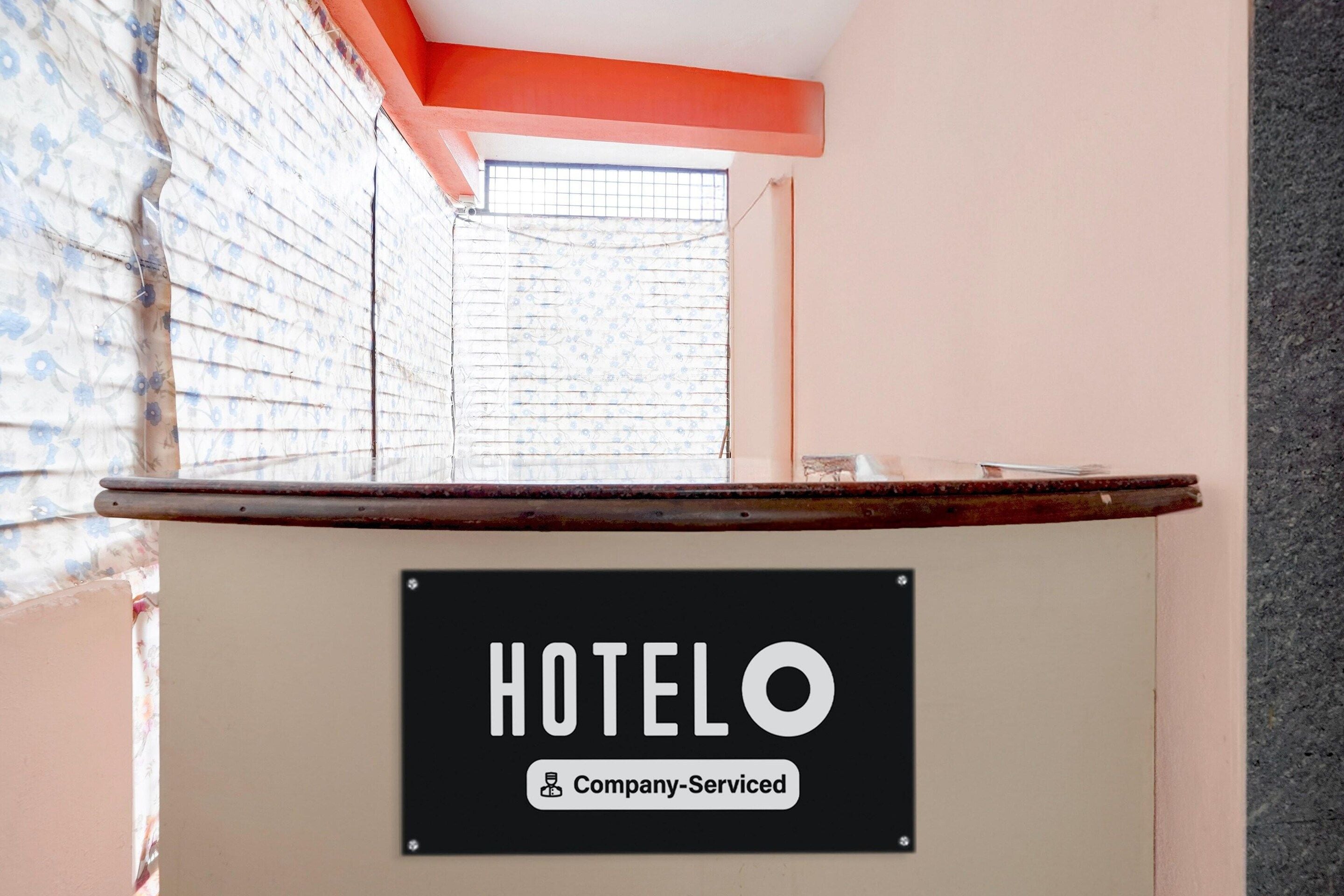 A reception desk with a sign that reads 'HOTELO Company-Serviced.'