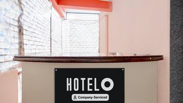 A reception desk with a sign that reads 'HOTELO Company-Serviced.'