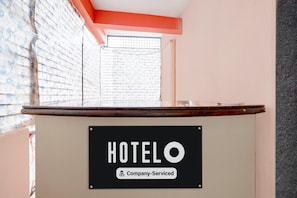 A reception desk with a sign that reads 'HOTELO Company-Serviced.'