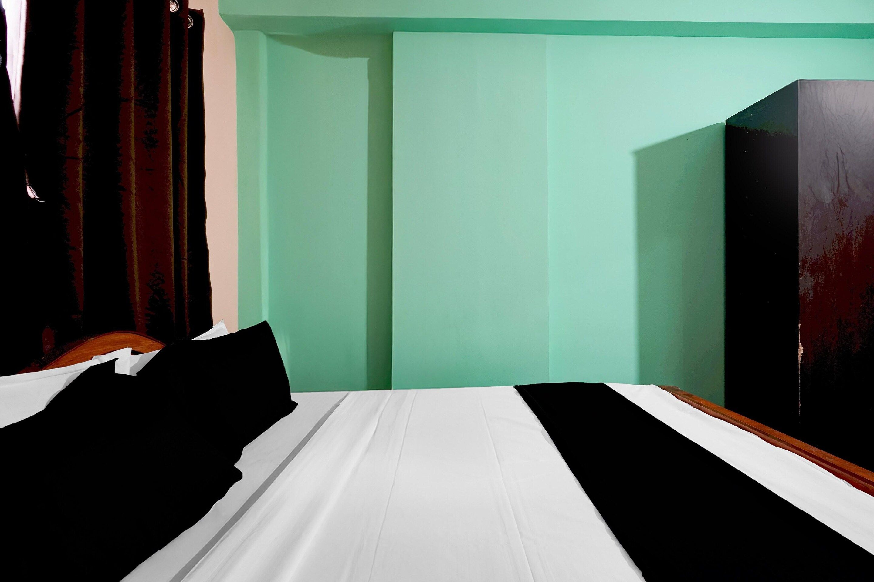 A bedroom with a bed, a wardrobe, and a mirror.